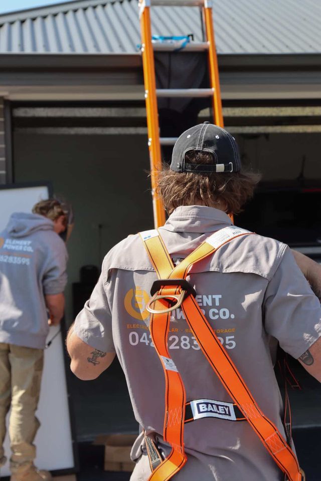 Element Power Co crew carrying equipment into a garage on install day